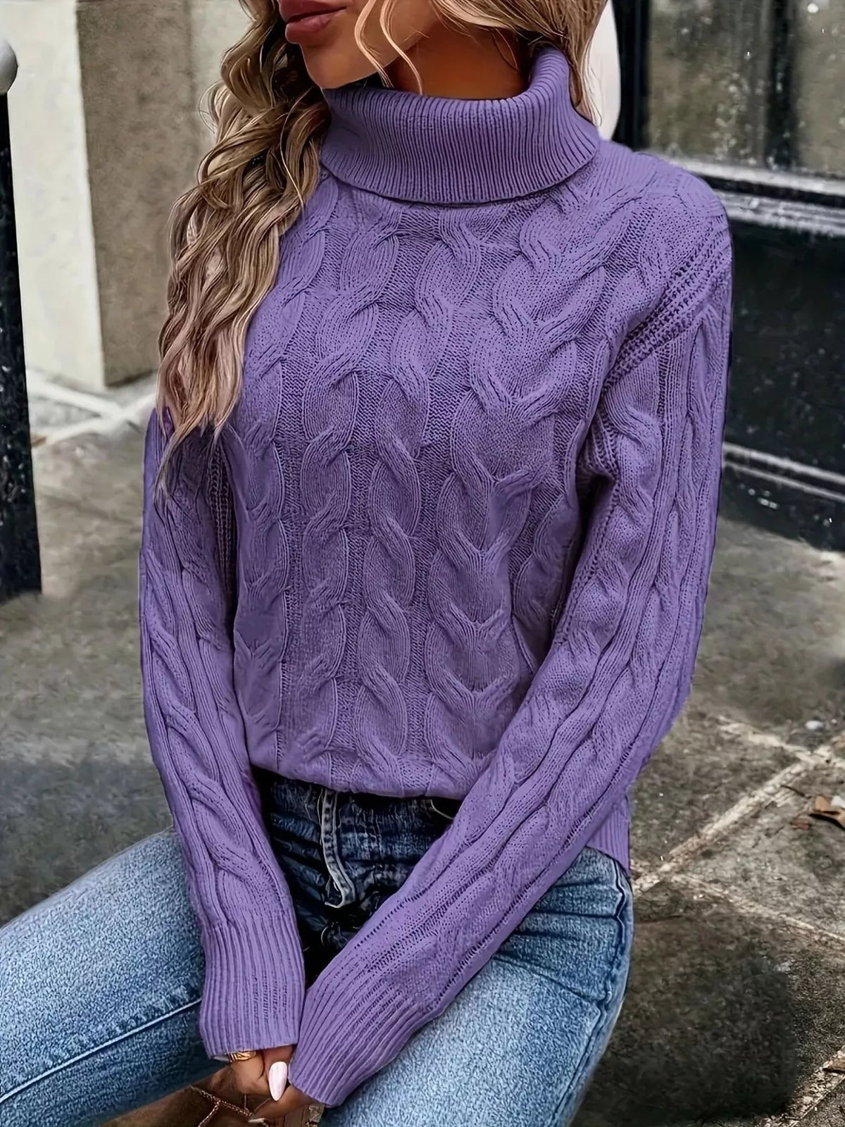 Woman wearing a purple cable knit turtleneck sweater with jeans