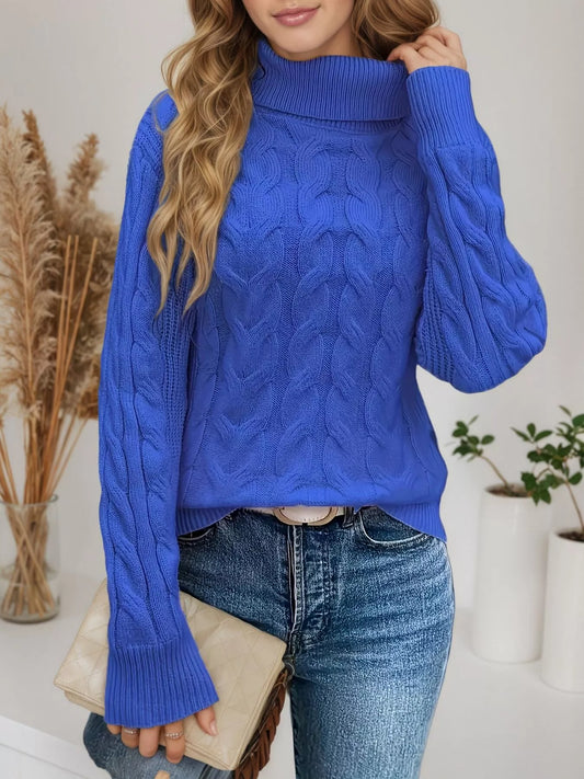 Woman wearing a royal blue cable knit turtleneck sweater with jeans