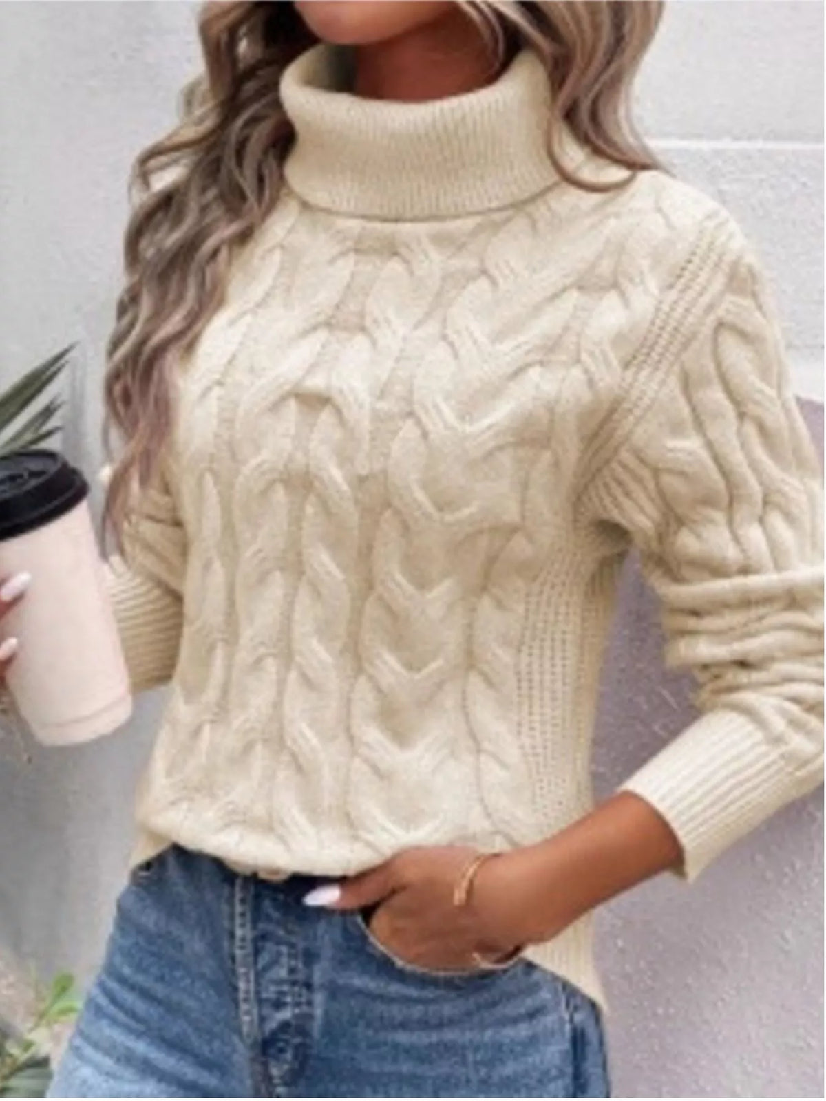 Woman wearing a apricot cable knit turtleneck sweater with jeans