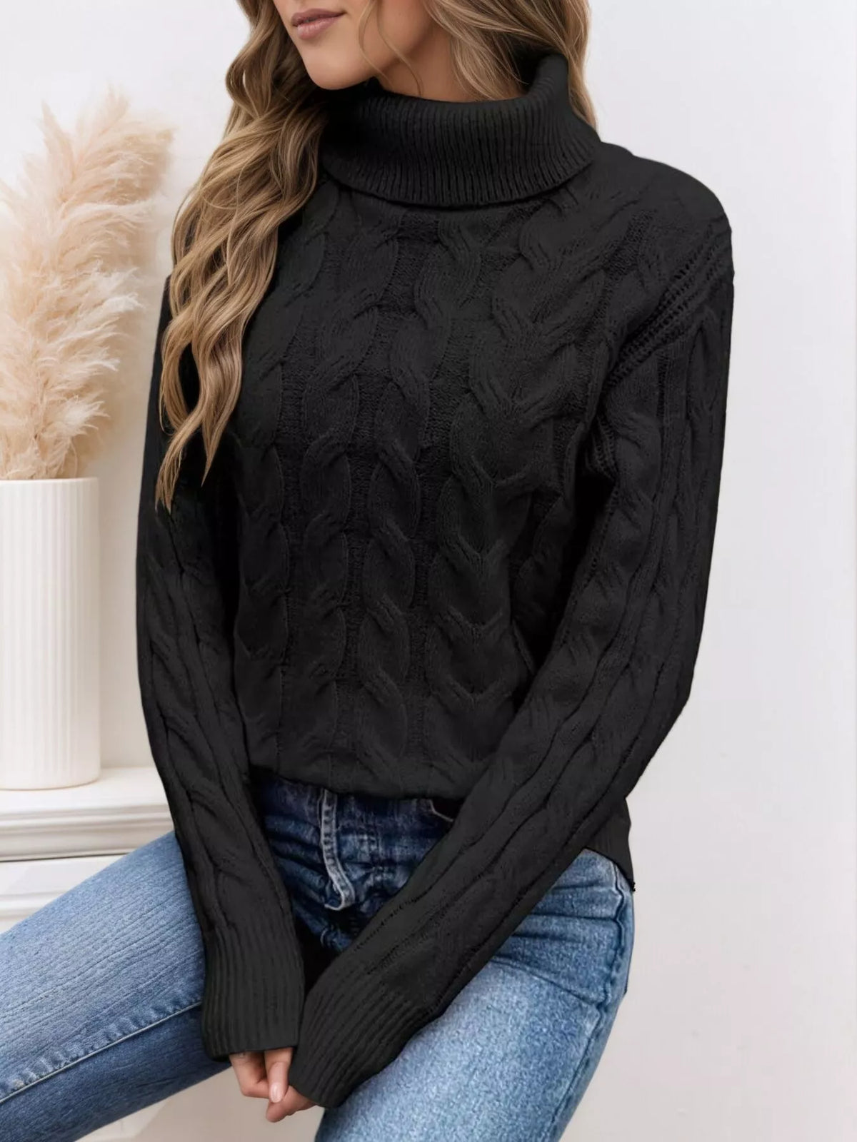 Woman wearing a black cable knit turtleneck sweater with jeans